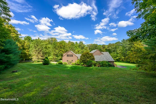 a view of a big yard with large tree and outdoor seating