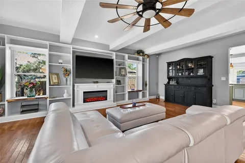 a living room with furniture a fireplace and a flat screen tv