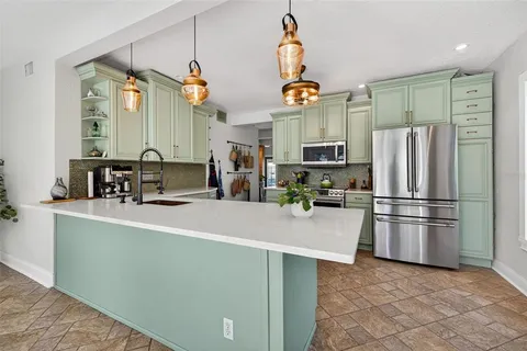 a kitchen with stainless steel appliances a refrigerator and a stove top oven