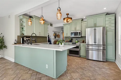 a kitchen with granite countertop a refrigerator stove top oven and sink