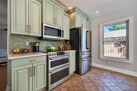 a kitchen with stainless steel appliances granite countertop a refrigerator sink and stove