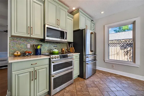 a kitchen with stainless steel appliances granite countertop a refrigerator sink and stove
