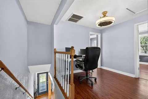 a view of a workspace with furniture and wooden floor