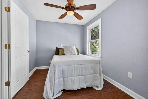 a bedroom with a large bed and wooden floor