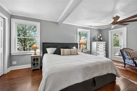 a bedroom with a bed and wooden floor