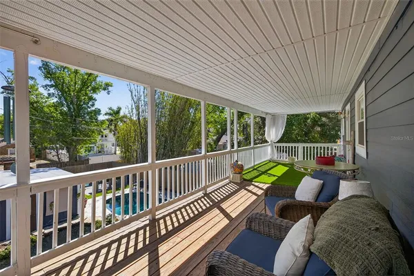 a view of a patio with couches chairs and wooden floor