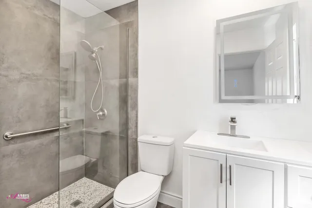 a bathroom with a sink a toilet and shower