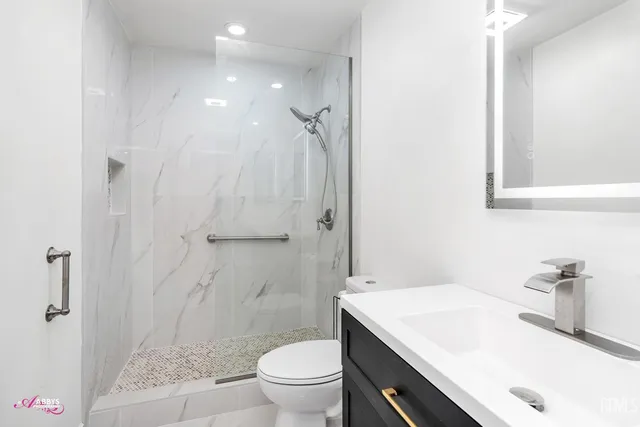 a bathroom with a sink a toilet and shower