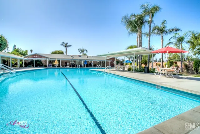 a view of a swimming pool with lawn chairs under an umbrella