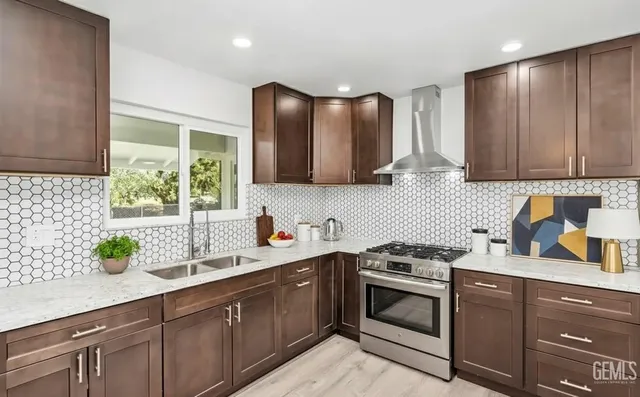 a kitchen with stainless steel appliances a sink stove and cabinets