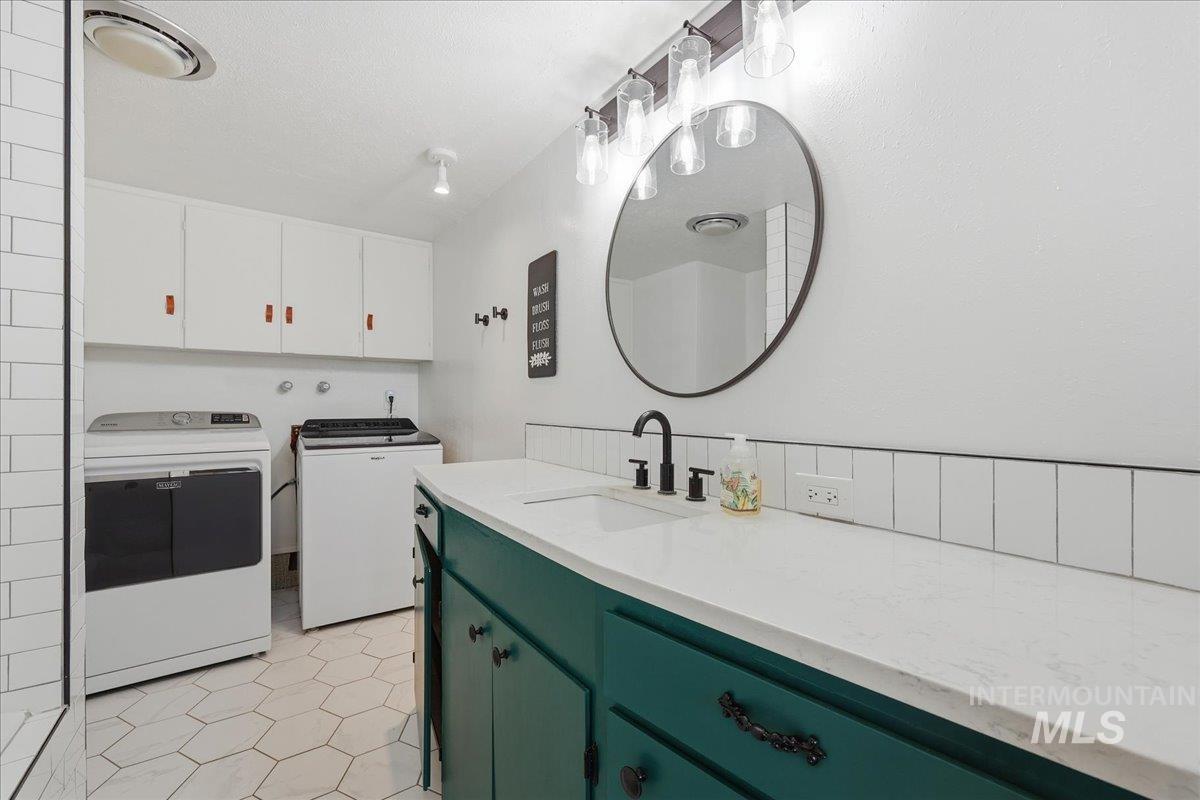 5405 Hogg Road Homedale, ID 83628 - Photo 21 of 29 Washroom featuring cabinet space, light tile patterned floors, and washer and clothes dryer