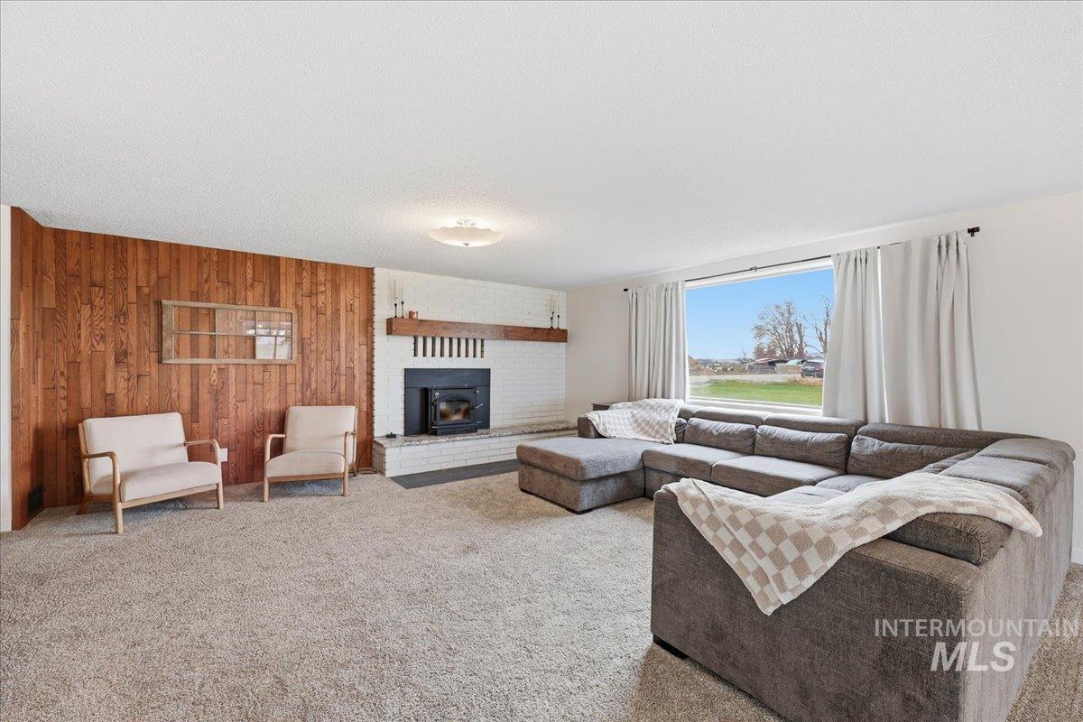 5405 Hogg Road Homedale, ID 83628 - Photo 6 of 29 Living room with wooden walls, carpet floors, and a textured ceiling