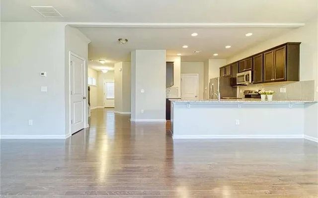 a living room with stainless steel appliances furniture or kitchen view and a refrigerator