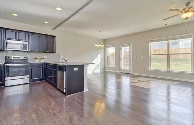 a kitchen with stainless steel appliances granite countertop a stove and a wooden floors