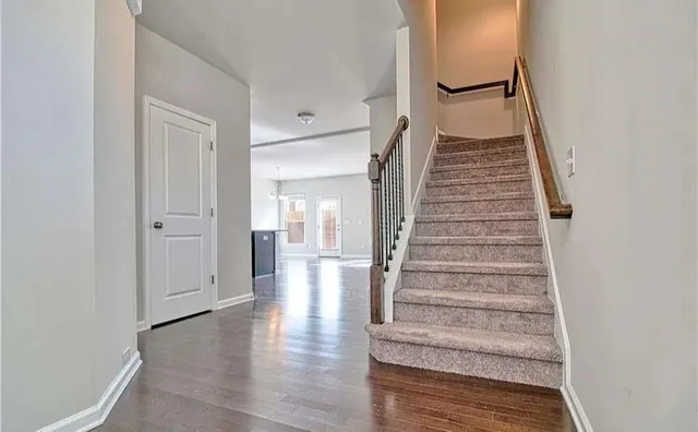 a view of a hallway with wooden floor and entryway