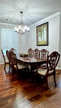 a view of a dining room with furniture wooden floor and chandelier