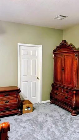 a bedroom with a bed and a cabinet