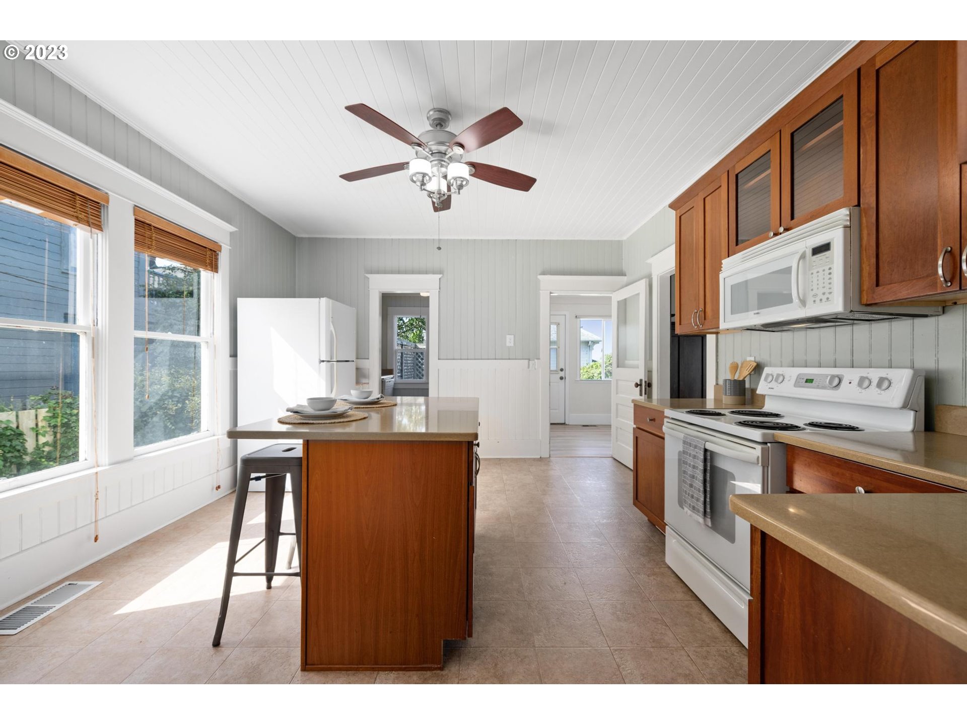 531 35th Street Astoria, OR 97103 - Photo 12 of 37 a open kitchen with stainless steel appliances granite countertop a stove top oven a sink dishwasher and white cabinets with wooden floor
