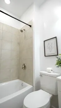 a white toilet sitting next to a bath tub