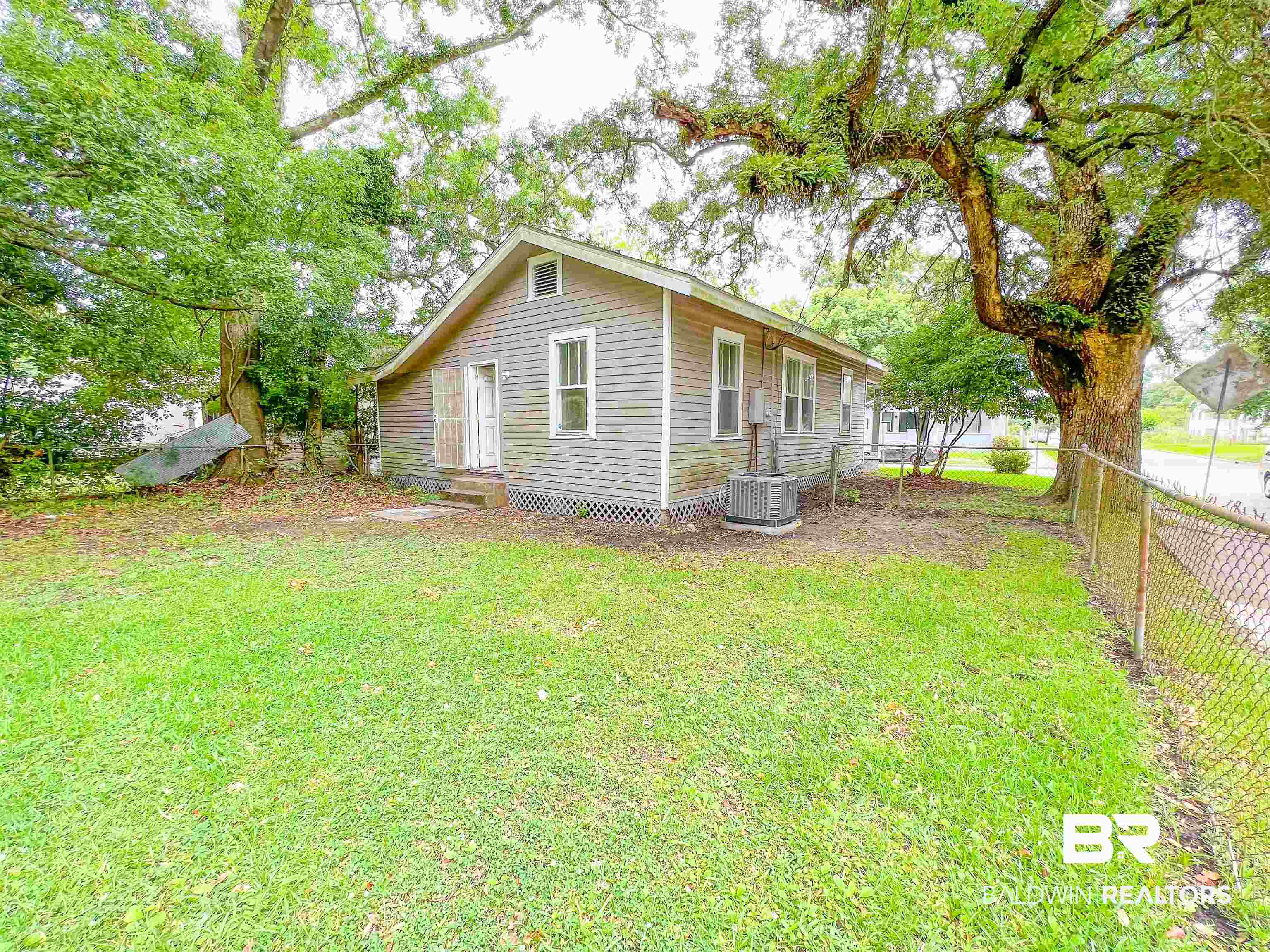 1164 Seneca Street Mobile, AL 36605 - Photo 21 of 22 View of home's exterior with entry steps, central air condition unit, fence, and a lawn