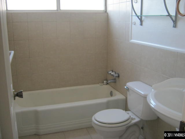 1225 Butler Street Reno, NV 89512 - Photo 8 of 12 a white bath tub sitting next to a white toilet and sink
