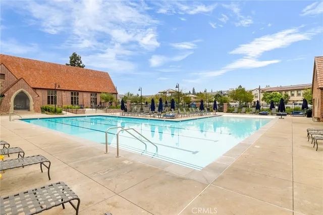 a view of swimming pool that has lawn chairs with plants and lake view