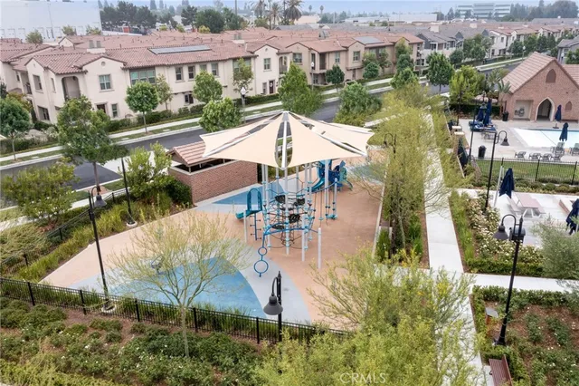 an aerial view of residential houses with outdoor space and parking