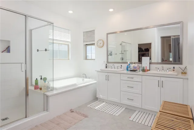 a bathroom with a double vanity sink mirror double and bathtub