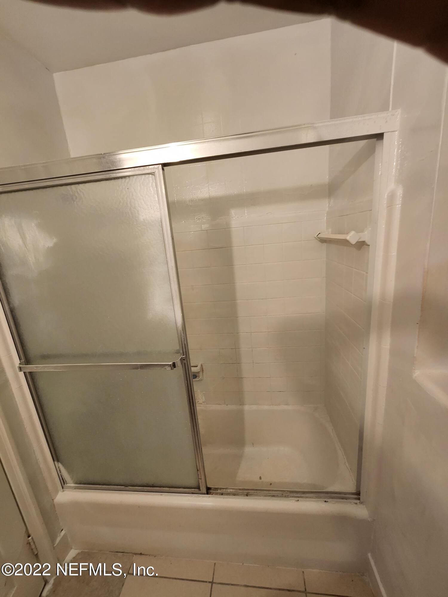 1914 Rogero Road Jacksonville, FL 32211 - Photo 10 of 18 a bathroom with a glass shower door