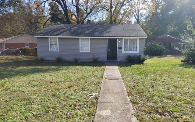 a front view of a house with a yard and pathway