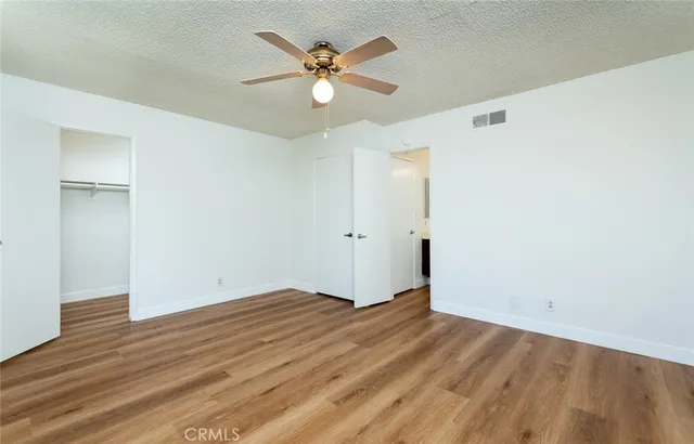 a view of a big room with wooden floor and windows