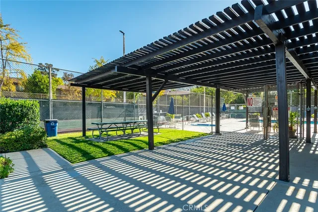 a swimming pool with lawn chairs under an umbrella