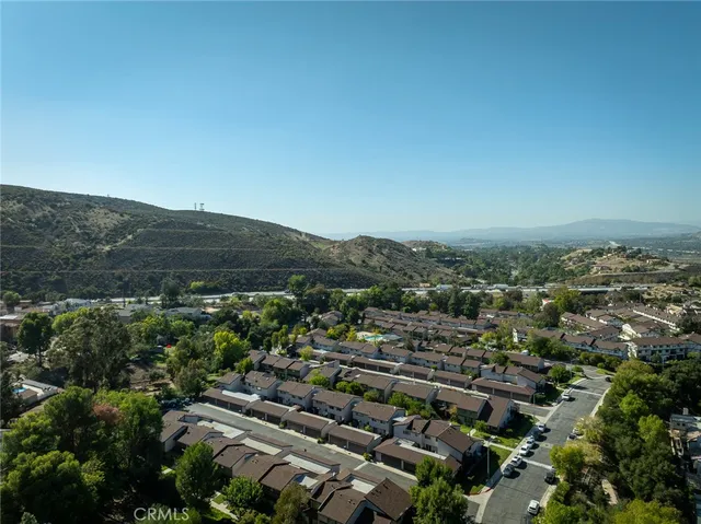 an aerial view of residential houses with outdoor space and trees