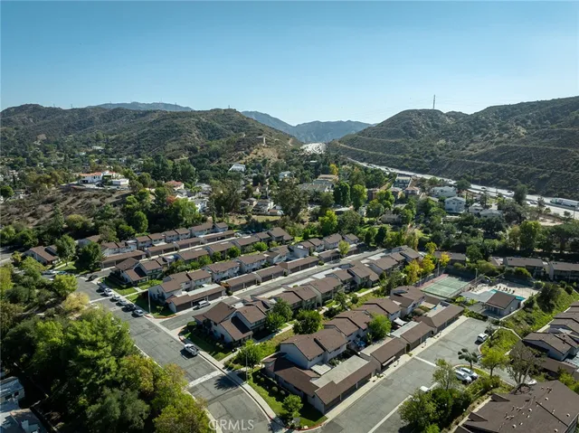 an aerial view of residential houses with outdoor space and trees