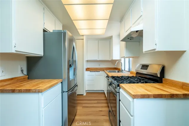 a kitchen with stainless steel appliances granite countertop a stove and a white cabinets