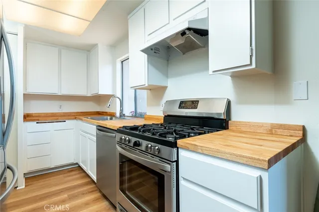 a kitchen with stainless steel appliances granite countertop a sink stove and cabinets