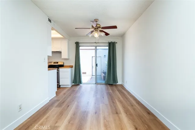 a kitchen view with wooden floor and a refrigerator
