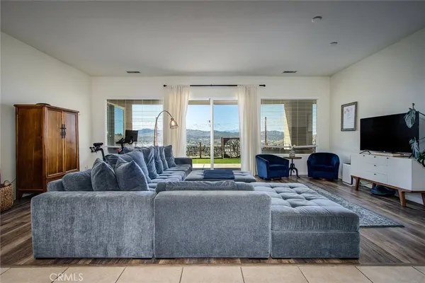 a living room with a couch a large window and a flat screen tv