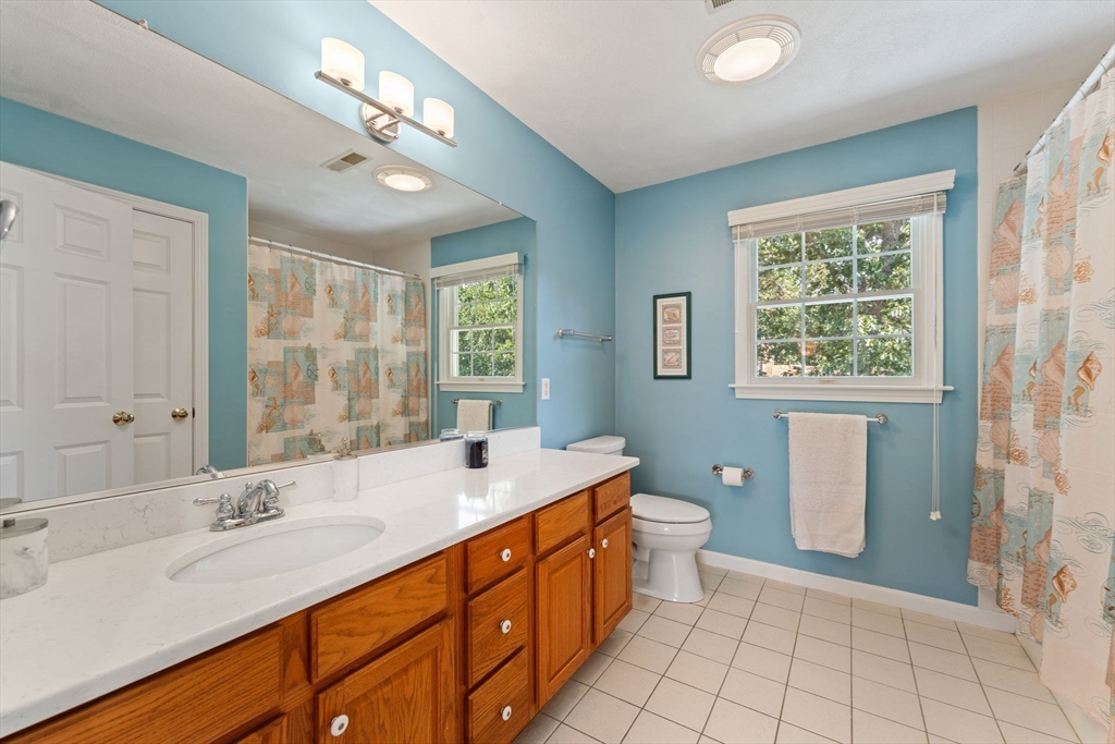 5 Spring House Lane Cumberland, RI 02864 - Photo 19 of 34 a spacious bathroom with a double vanity sink a toilet a mirror and a shower