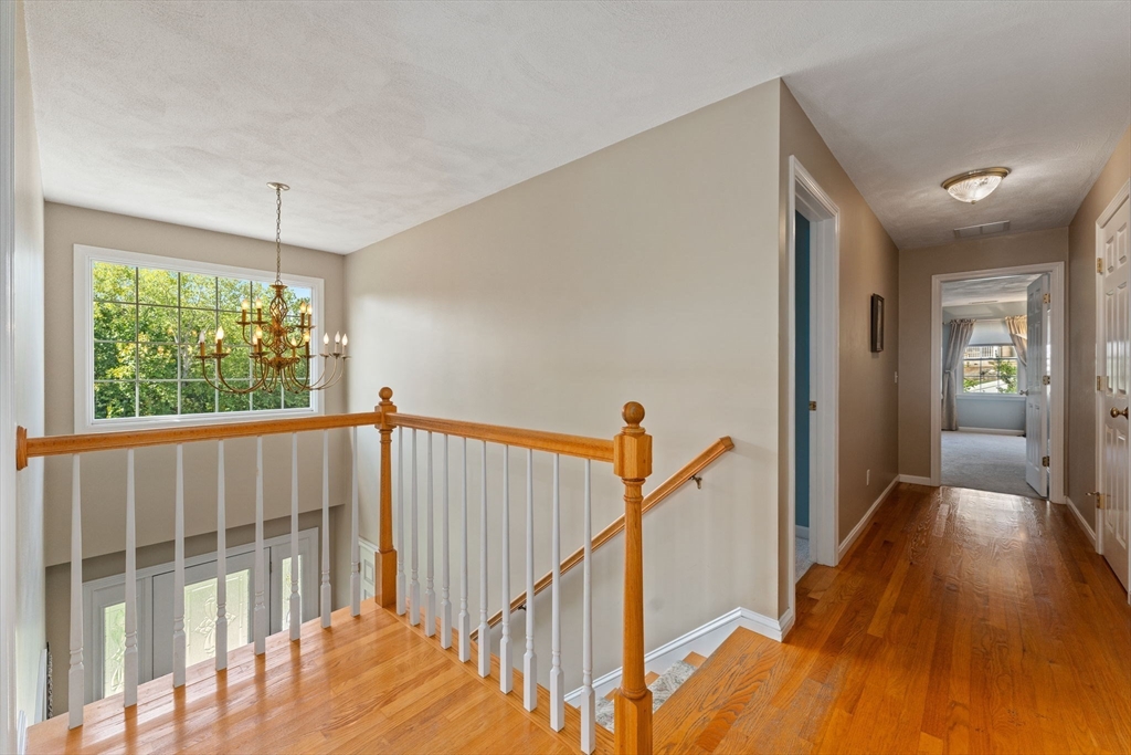 5 Spring House Lane Cumberland, RI 02864 - Photo 20 of 34 a view of hallway with wooden floor and a chandelier