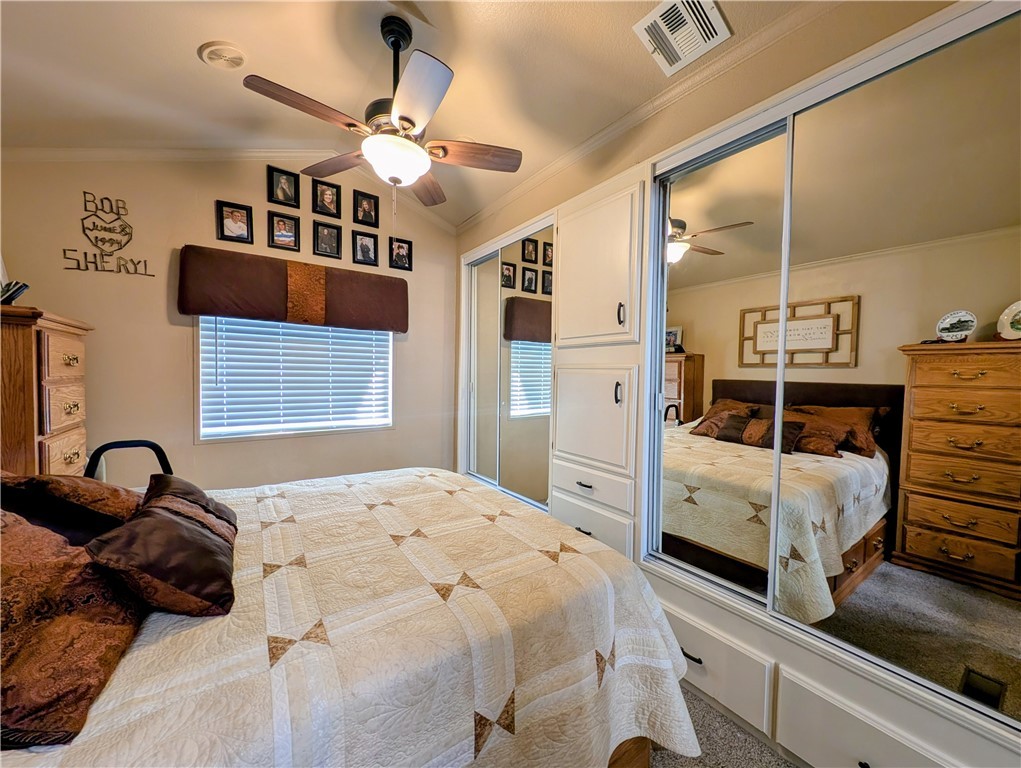 2000 Ramar Road, Unit 442 Bullhead City, AZ 86442 - Photo 22 of 28 Bedroom featuring crown molding, ceiling fan, carpet, lofted ceiling, and two closets