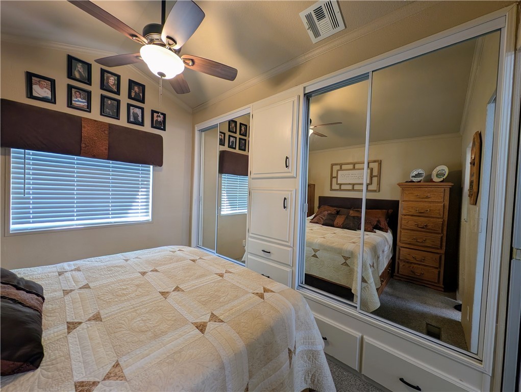 2000 Ramar Road, Unit 442 Bullhead City, AZ 86442 - Photo 23 of 28 Carpeted bedroom with multiple closets, ornamental molding, ceiling fan, and lofted ceiling