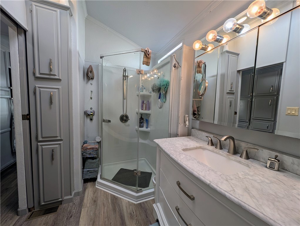 2000 Ramar Road, Unit 442 Bullhead City, AZ 86442 - Photo 26 of 28 Full bath featuring vanity, a shower stall, light wood finished floors, and crown molding