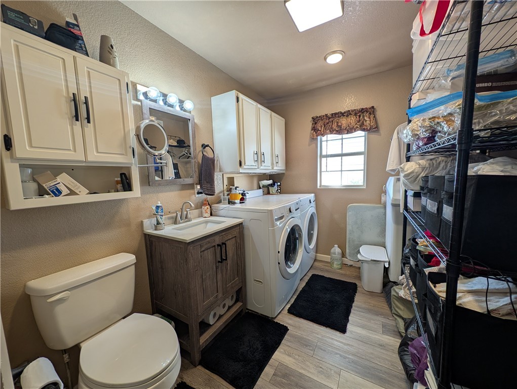 2000 Ramar Road, Unit 442 Bullhead City, AZ 86442 - Photo 27 of 28 Bathroom with washing machine and dryer, a textured wall, light wood-style floors, and vanity