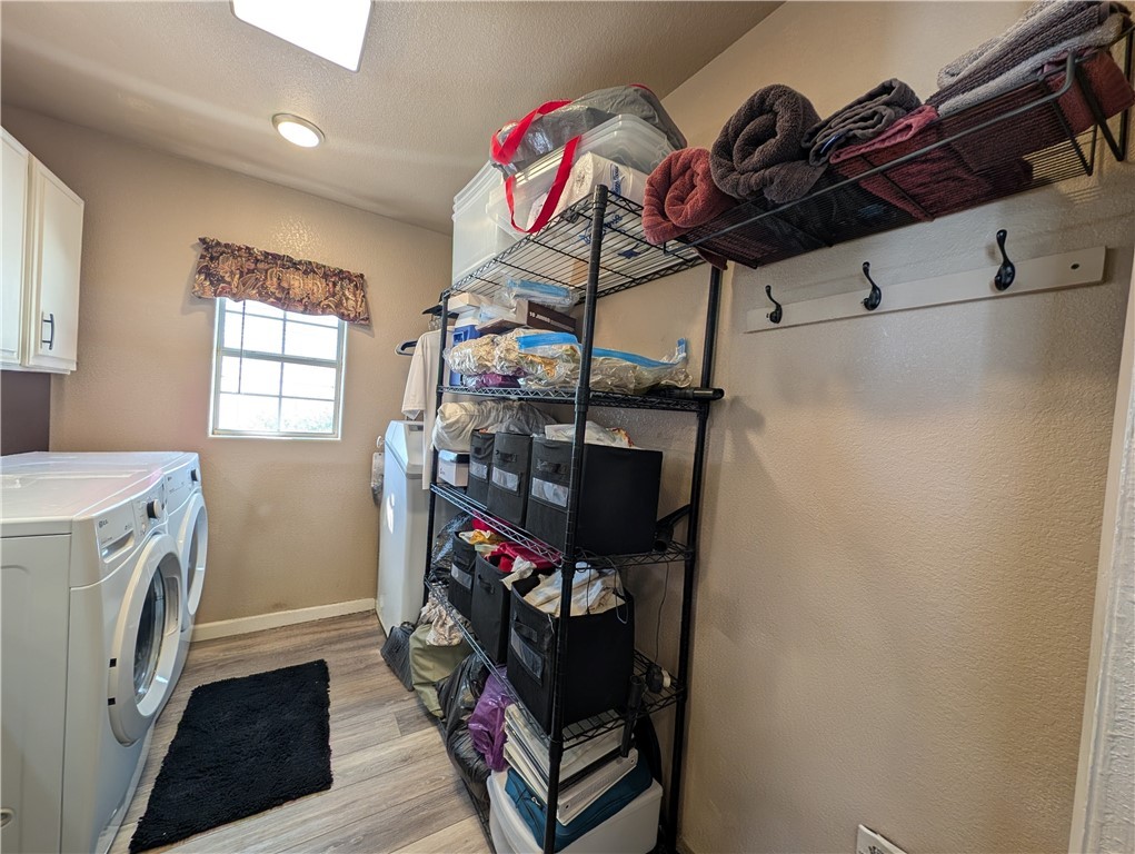 2000 Ramar Road, Unit 442 Bullhead City, AZ 86442 - Photo 28 of 28 Laundry room with light wood-style floors, washer and dryer, a textured ceiling, and cabinet space