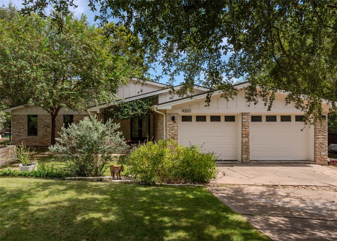 4203 Afton Lane Austin, TX 78744 - Photo 2 of 24 a view of a white house next to a yard with potted plants and large trees
