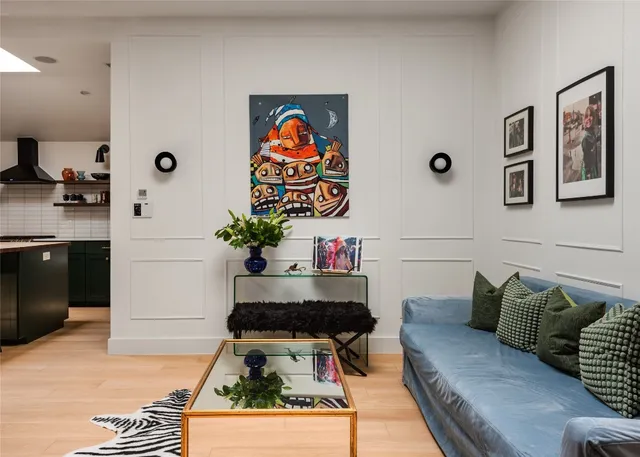 a living room with furniture and wall paintings