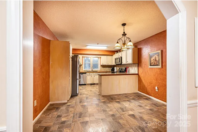 a kitchen with granite countertop a refrigerator and a stove top oven