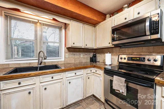 a kitchen with a sink stove and microwave