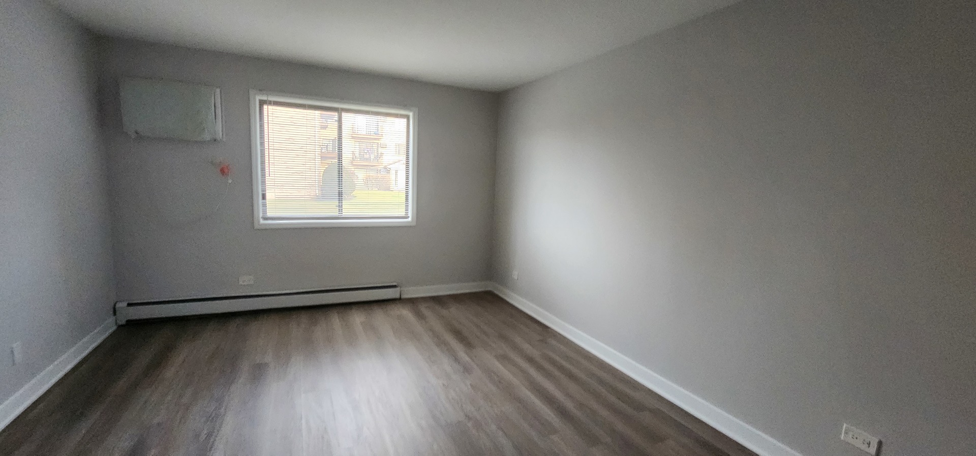9290 Hamilton Court, Unit A Des Plaines, IL 60016 - Photo 5 of 10 an empty room with wooden floor and windows